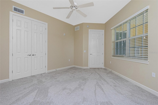 unfurnished bedroom featuring a closet, light carpet, and ceiling fan