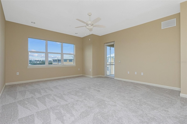 empty room with light colored carpet, ceiling fan, and plenty of natural light