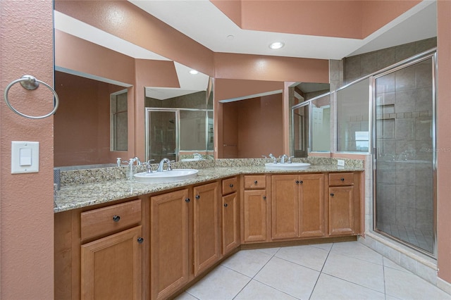 bathroom with walk in shower, tile floors, and dual bowl vanity