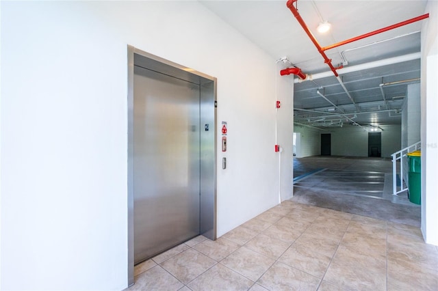 corridor with light tile floors and elevator