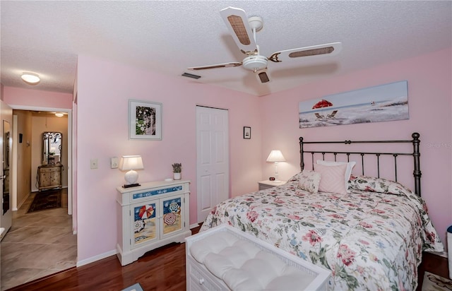 tiled bedroom featuring a closet, ceiling fan, and a textured ceiling