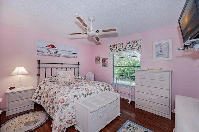 bedroom featuring ceiling fan, a textured ceiling, and dark wood-type flooring