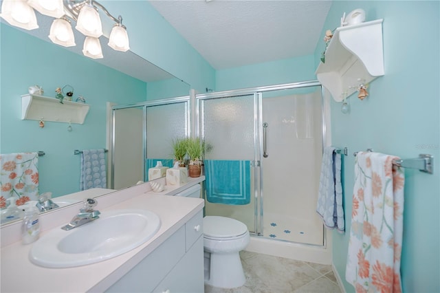 bathroom with toilet, a shower with shower door, tile floors, a textured ceiling, and vanity