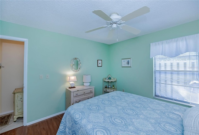 bedroom with ceiling fan, a textured ceiling, and dark tile flooring