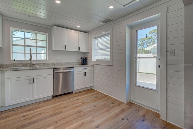 kitchen featuring white cabinetry, stainless steel dishwasher, a healthy amount of sunlight, and light wood-type flooring