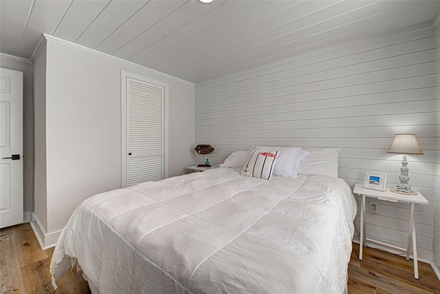 bedroom featuring ornamental molding, a closet, and light wood-type flooring