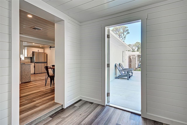 doorway to outside featuring wood ceiling and light hardwood / wood-style flooring