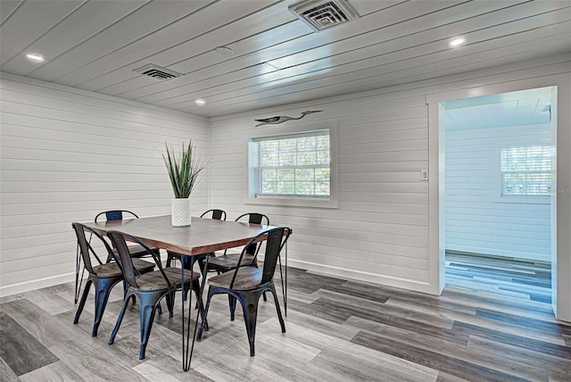 dining area featuring wooden walls, hardwood / wood-style floors, and wood ceiling