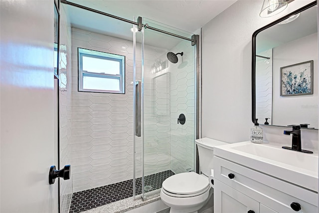 bathroom featuring toilet, a shower with door, and large vanity