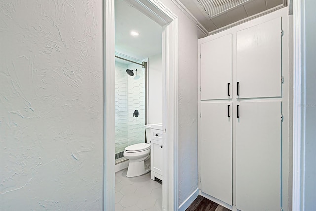 bathroom featuring crown molding, toilet, wood-type flooring, and a shower with shower door