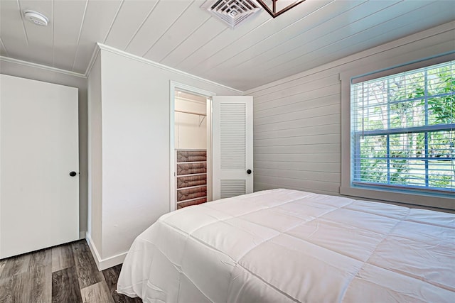 bedroom featuring a closet, dark hardwood / wood-style floors, and ornamental molding