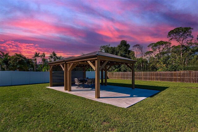 yard at dusk featuring a gazebo and a patio area