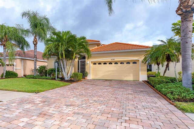 mediterranean / spanish home with a front lawn and a garage