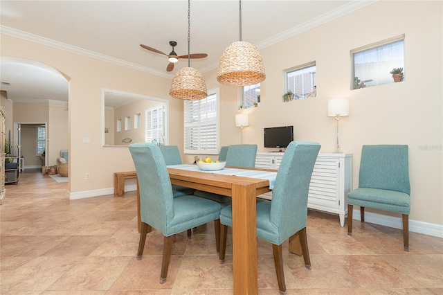 tiled dining area featuring ceiling fan and crown molding