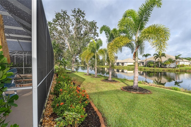 view of yard with glass enclosure and a water view