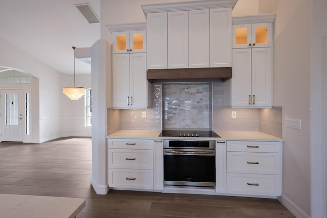 kitchen with white cabinets, decorative backsplash, and oven