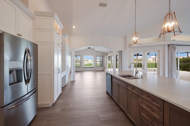 kitchen with french doors, sink, appliances with stainless steel finishes, decorative light fixtures, and white cabinetry