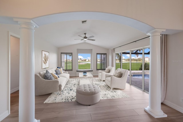 living room featuring ceiling fan, ornate columns, a wealth of natural light, and vaulted ceiling