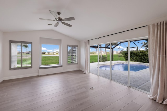 interior space with ceiling fan, lofted ceiling, and light wood-type flooring