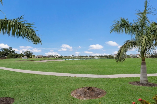 view of home's community with a lawn and a water view