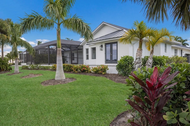 exterior space featuring french doors, a front lawn, and a lanai