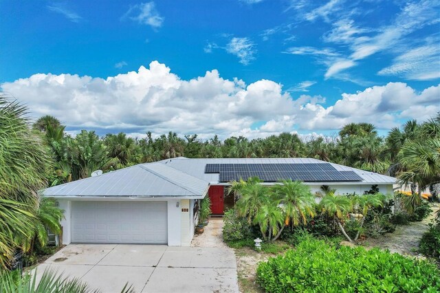 single story home with solar panels and a garage