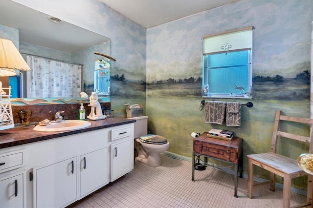 bathroom with tile floors, toilet, and vanity