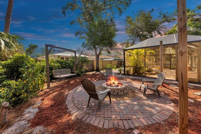 patio terrace at dusk with a fire pit and glass enclosure