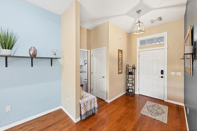 foyer featuring dark wood-style flooring, visible vents, and baseboards