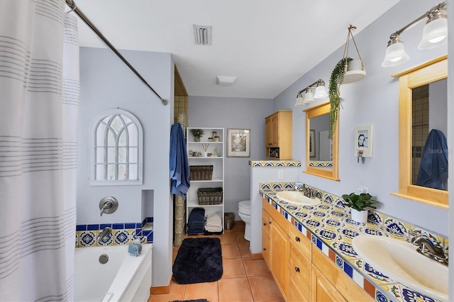 bathroom with tile patterned flooring, a sink, toilet, and double vanity