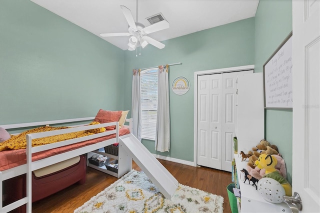 bedroom with dark wood-style floors, a closet, visible vents, ceiling fan, and baseboards