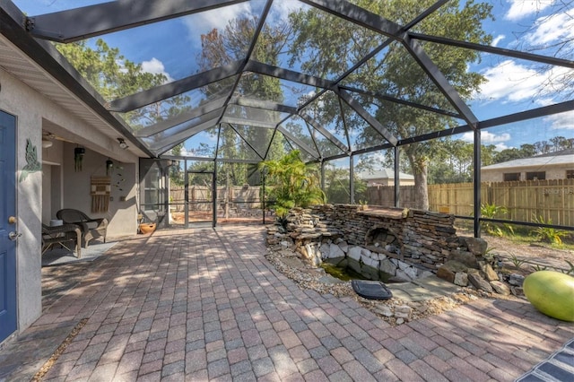 view of patio with a lanai and a fenced backyard