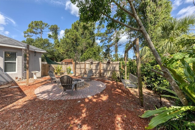 view of yard featuring a patio area, a fenced backyard, and a fire pit