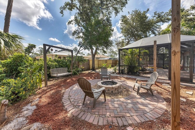 view of patio / terrace with glass enclosure, fence, and a fire pit