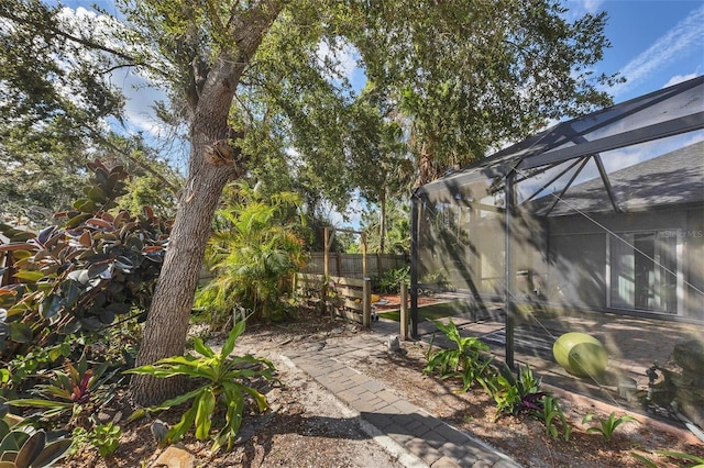 view of yard featuring glass enclosure and fence