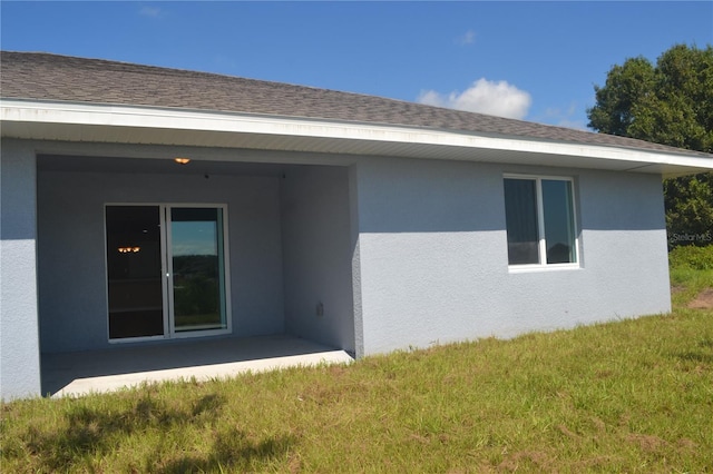 rear view of property with a lawn and a patio area