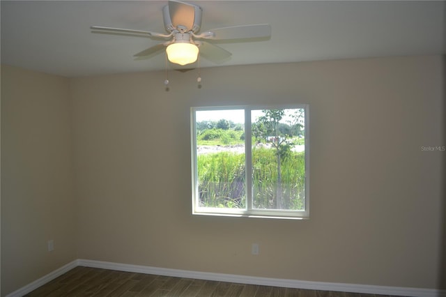 spare room featuring ceiling fan and dark wood-type flooring