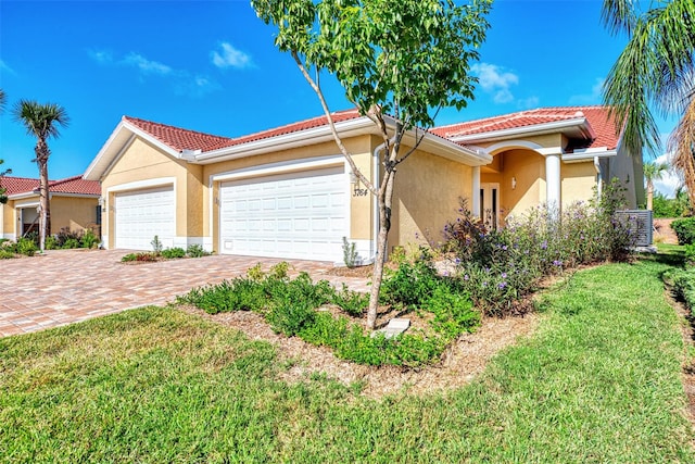 mediterranean / spanish-style home with a front lawn and a garage