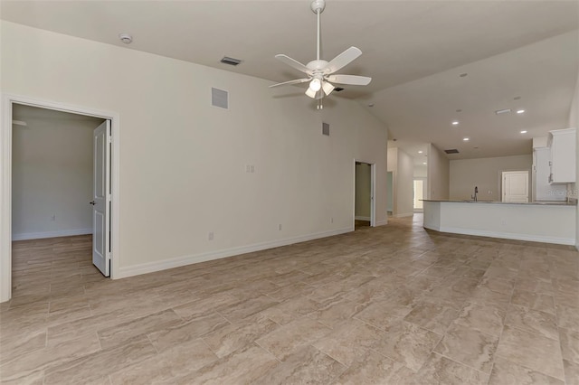 unfurnished living room featuring high vaulted ceiling, ceiling fan, light tile floors, and sink