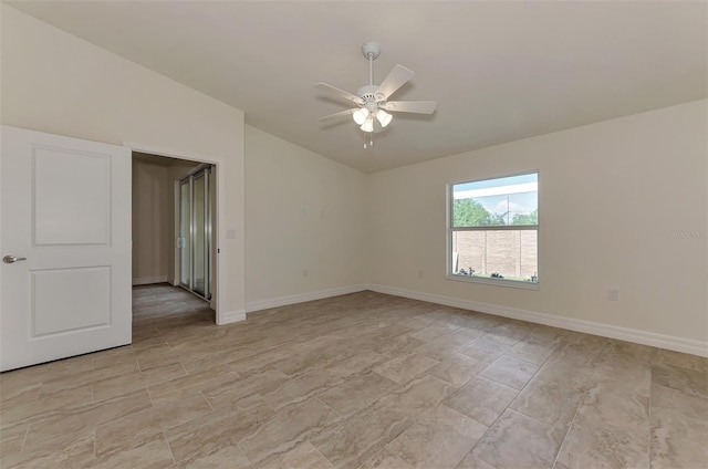 tiled spare room with vaulted ceiling and ceiling fan