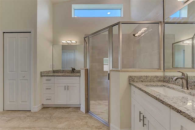 bathroom featuring an enclosed shower, tile flooring, vanity with extensive cabinet space, and a high ceiling