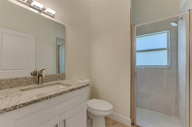 bathroom featuring toilet, vanity, a shower with door, and tile flooring