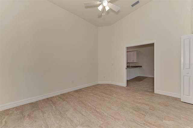 tiled spare room with high vaulted ceiling and ceiling fan