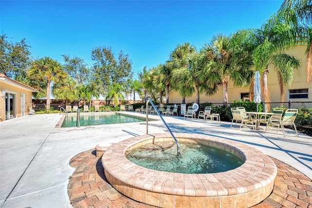 view of pool with a community hot tub and a patio area