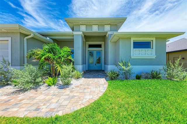 entrance to property with a lawn and french doors