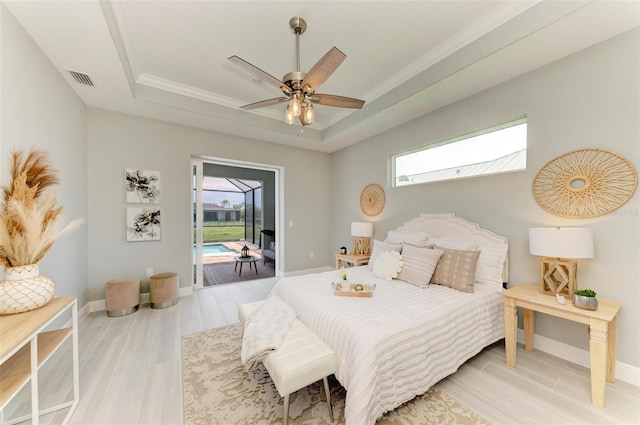 bedroom with a tray ceiling, access to exterior, ceiling fan, and light wood-type flooring