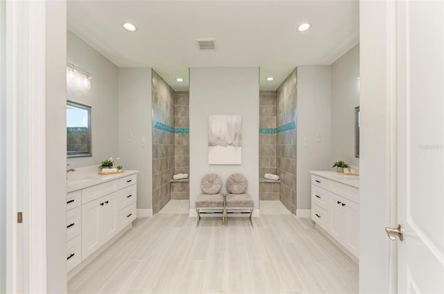 bathroom featuring tile floors, tiled shower, and large vanity