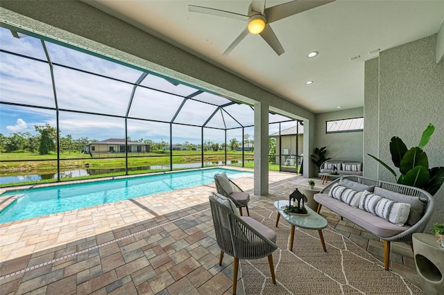 view of swimming pool with a patio, ceiling fan, an outdoor living space, and a lanai