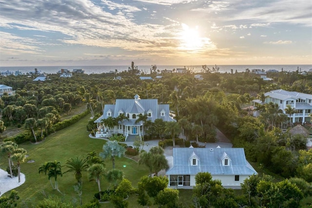 aerial view at dusk featuring a water view