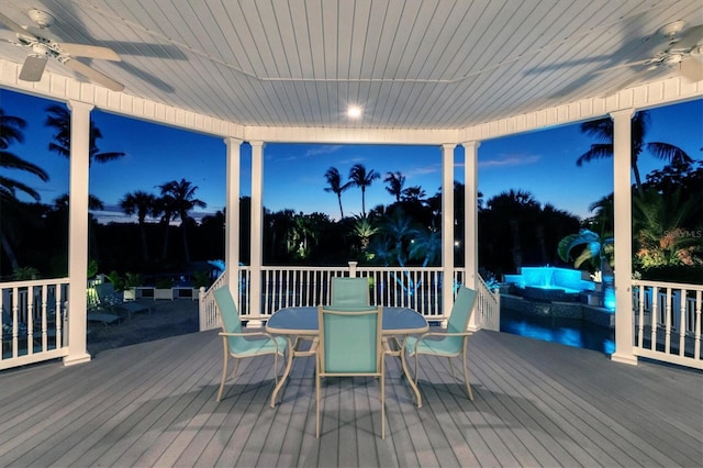 deck at dusk featuring ceiling fan and an outdoor living space